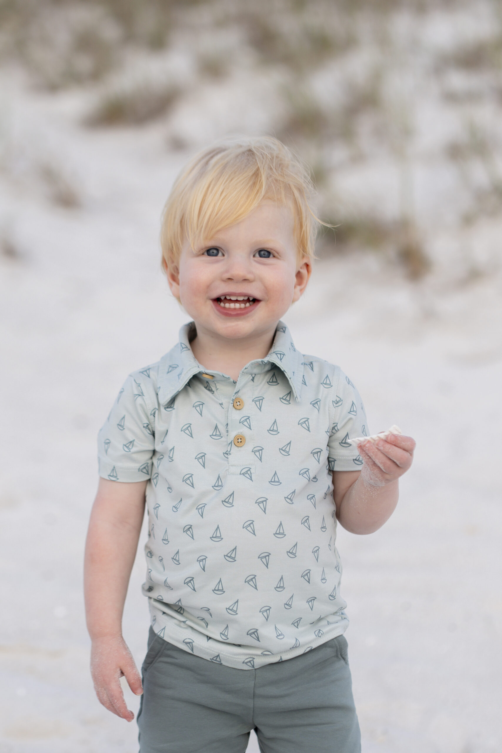 Close-up of child playing with shells near the shoreline at the Destin Jetties.